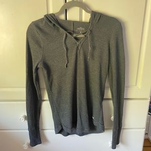 Long sleeve grey sweater with a hood.